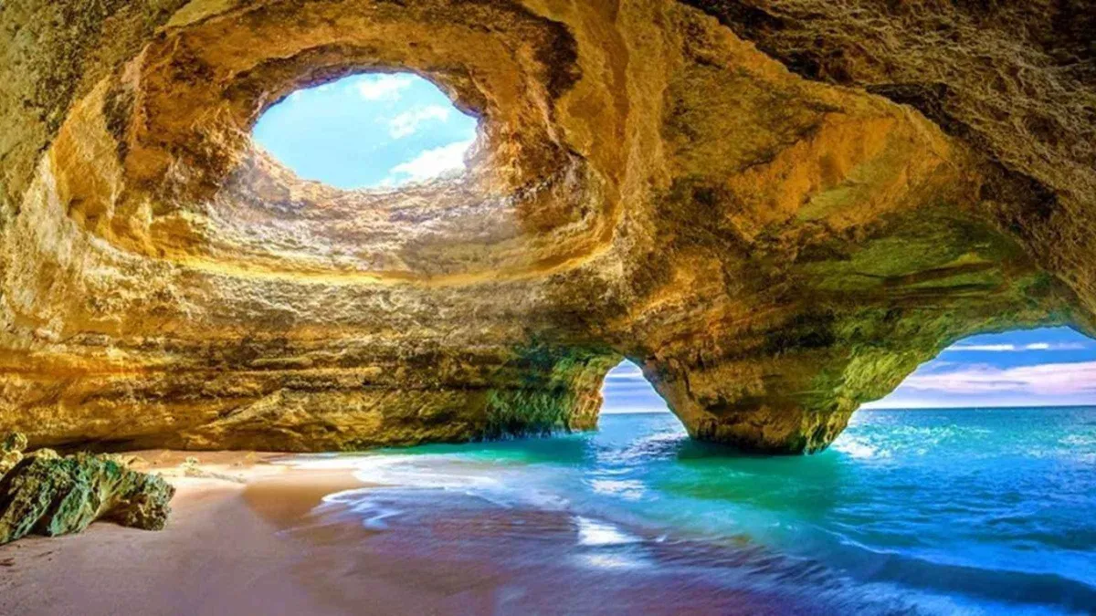 Small boat tour idling at the mouth of the Benagil sea cave near Portimão on the Algarve coast, Portugal